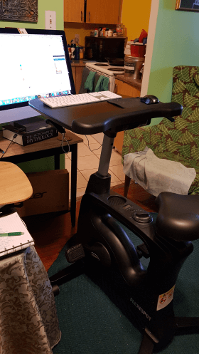 Exercise bike configured with a keyboard and laptop stand