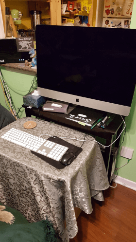 Makeshift office setup with keyboard stand and monitor